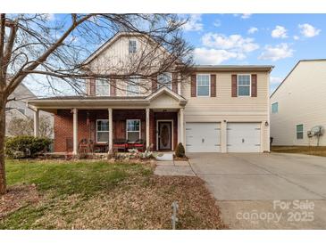 Charming two-story home with a welcoming front porch and a two-car attached garage at 2415 Impatien Dr, Charlotte, NC 28215