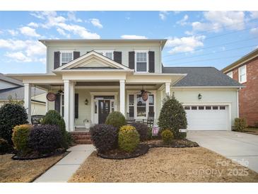 Charming two-story home features a welcoming front porch with classic columns and a two-car garage at 328 Sensibility Cir, Fort Mill, SC 29708