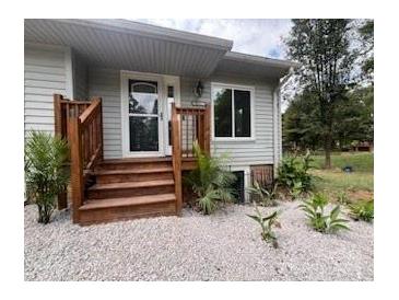 Charming home featuring a light gray exterior and a welcoming wood staircase leading to the front door at 3995 Burton Ln, Denver, NC 28037