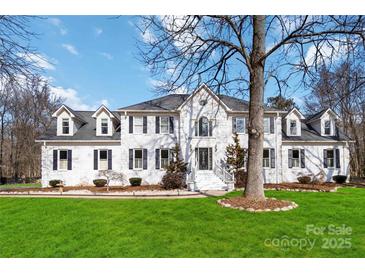 Two-story white brick home with a large front yard and mature trees at 4001 Carmel Acres Dr, Charlotte, NC 28226