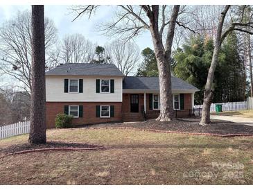 Charming two-story brick home featuring green shutters, black front door, and a well-maintained front yard at 8025 Cliffside Dr, Charlotte, NC 28270