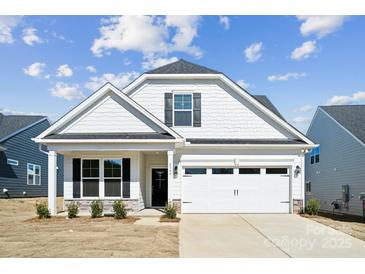 Charming single-Gathering home showcasing a well-manicured lawn, attached two-car garage, and classic architectural details at 8348 Acadia Pkwy, Sherrills Ford, NC 28673