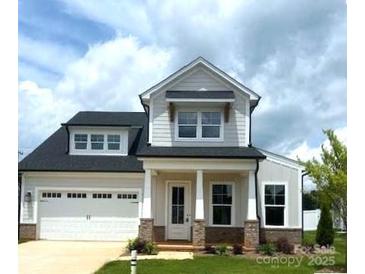 Charming two-story home featuring a 2-car garage and landscaped yard at 13708 Tranquil Day Dr, Matthews, NC 28105