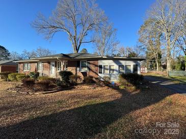 Brick ranch home with a sunroom and a deck in the backyard at 518 Glenn St, Chester, SC 29706