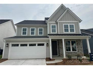 Charming two-story home with gray siding, stone accents, and a two-car garage at 7120 Wayfarer Dr # 0079, Charlotte, NC 28269