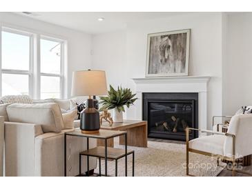 Bright living room features a cozy fireplace, plush seating, and stylish decor accents at 7120 Wayfarer Dr # 0079, Charlotte, NC 28269