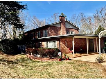 Brick home with covered patio, landscaping, and detached shed at 110 30Th Nw Ave, Hickory, NC 28601