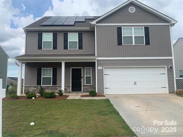 Two-story house with gray siding, solar panels, and a white garage door at 1112 Culver Spring Way, Charlotte, NC 28215