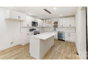 Bright kitchen featuring white cabinetry, stainless appliances, and a center island with pendant lighting at 1712 S Main St, Salisbury, NC 28144