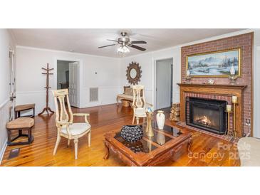 Living room featuring hardwood floors, fireplace and seating area at 202 W Main St, Cherryville, NC 28021