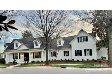 Charming two-story white brick home with a black roof, black shutters and a inviting front porch at 357 Magnolia St, Davidson, NC 28036