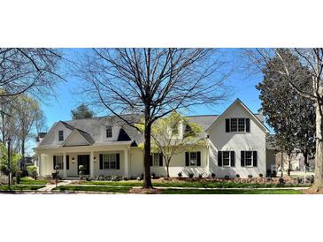 Charming white brick home featuring black shutters and a manicured front yard, exuding classic elegance at 357 Magnolia St, Davidson, NC 28036