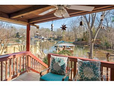 Covered porch overlooks a peaceful lake with boats and waterfront homes at 513 Paradise Cir, Belmont, NC 28012