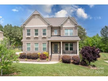 Charming two-story brick home featuring a well-manicured lawn and inviting front porch at 6361 Willow Farm Dr, Denver, NC 28037