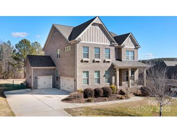 Two-story brick home with a three-car garage and driveway at 6361 Willow Farm Dr, Denver, NC 28037