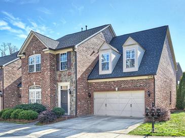 Charming two-story brick home features a two-car garage and manicured landscaping at 712 English Tudor Ln, Charlotte, NC 28211