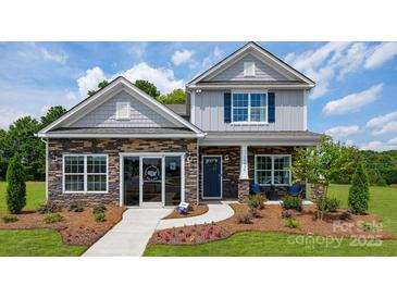 Two-story house with gray siding, stone accents, and landscaped yard at 10630 Tuff Ln, Davidson, NC 28036