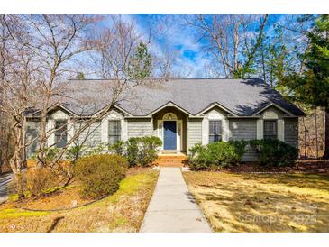 Charming single-story home with a blue front door, landscaped yard, and a welcoming walkway at 12104 Baywoods Dr, Tega Cay, SC 29708