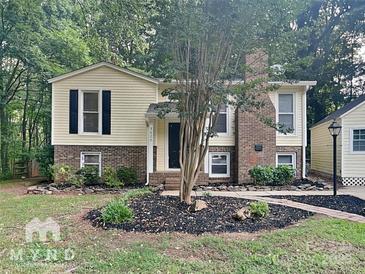 Ranch style home with brick facade and landscaped yard at 3029 Winding Trl, Matthews, NC 28105