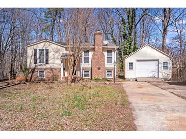 Charming split-level home with brick chimney, detached garage and inviting curb appeal at 3029 Winding Trl, Matthews, NC 28105