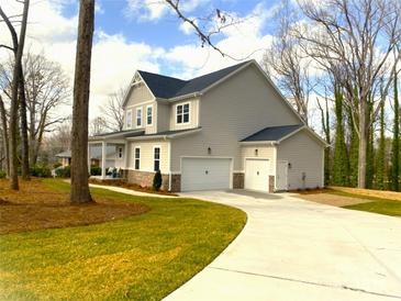 A charming two-story home with a two-car garage and a well-manicured lawn with beautiful green grass at 553 W Lowrance Ave, Mooresville, NC 28115