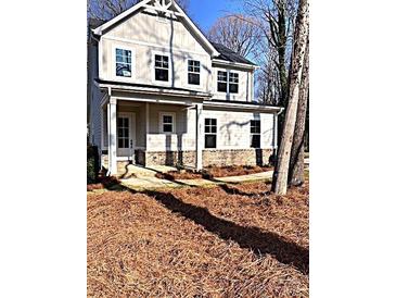 Charming two-story home with a covered porch, multiple windows, and manicured front lawn at 553 W Lowrance Ave, Mooresville, NC 28115