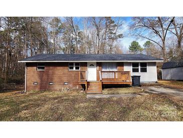 Brick ranch house with wooden deck and small yard at 704 W Border St, Dallas, NC 28034