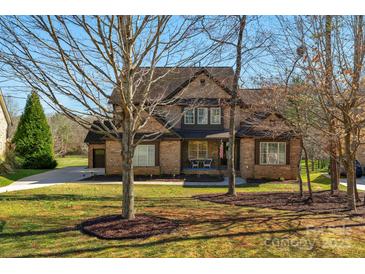 Charming two-story brick home with a well-manicured lawn and covered front porch at 7219 Yellowhorn Trl, Waxhaw, NC 28173