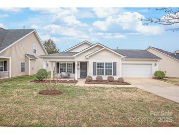 Charming single-story home with a well-manicured lawn and inviting front porch at 8714 Summer Serenade Dr, Huntersville, NC 28078