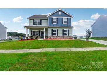 Two-story house with blue and green siding, landscaping, and a paved driveway at 3915 Allenby Pl, Monroe, NC 28110