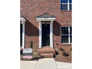 Brick townhouse with a black front door and small steps leading to the entrance at 451 Beacon Nw St # 6, Concord, NC 28027