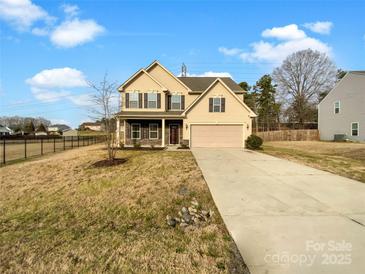 Two-story house with a beige exterior, stone accents, and a two-car garage at 4903 Greenloch Ct, Monroe, NC 28110