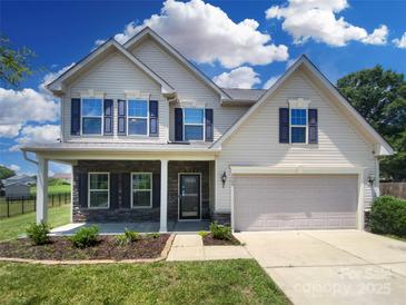 Charming two-story home with stone accents, a two-car garage, and a beautifully landscaped front yard at 4903 Greenloch Ct, Monroe, NC 28110