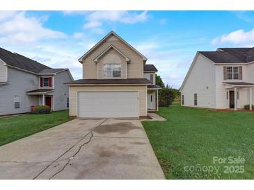 Two-story house with a beige exterior, attached garage, and a well-maintained lawn at 5813 Bridgeway Dr, Indian Trail, NC 28079