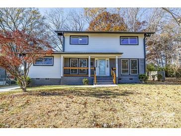 Two-story house with gray and white siding, a light-colored door, and a landscaped yard at 6309 Spring Garden Ln, Charlotte, NC 28213