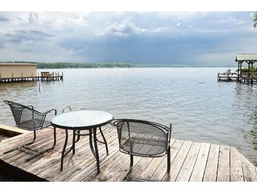 Charming waterfront view featuring a table and chairs on the deck overlooking the serene lake at 670 Allenton St, Norwood, NC 28128