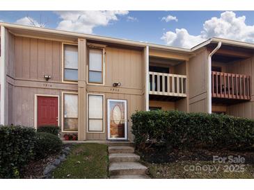 Two-story condo building exterior with landscaping and steps leading to the entrance at 7912 Charter Oak Ln, Charlotte, NC 28226