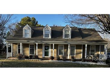 Charming single Gathering home featuring dormer windows, covered porch, and mature landscaping at 12325 Parks Farm Ln, Charlotte, NC 28277