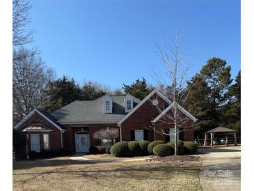 Charming brick home featuring well-manicured landscaping, mature trees, and a welcoming front entrance, gazebo in backyard at 13501 Misty Dew Ct # 19, Charlotte, NC 28273