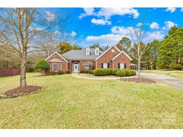 Charming brick home with manicured lawn, mature trees, and inviting walkway to the front entrance at 13501 Misty Dew Ct # 19, Charlotte, NC 28273