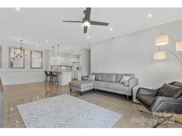 Bright living room featuring an open floorplan, modern ceiling fan, and stylish grey sofa at 16436 Redstone Mountain Ln, Charlotte, NC 28277