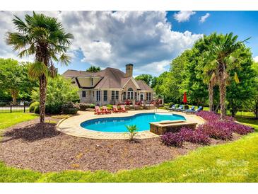 Resort style pool and patio area complete with lounge chairs and tropical landscaping in backyard of home at 1765 Old Clay Hill Rd, York, SC 29745