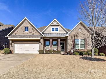 Charming brick home with a manicured front yard and a two-car garage beneath a clear blue sky at 2001 Arbor Hills Dr, Indian Trail, NC 28079