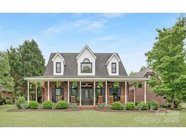 Charming brick home with a wide, covered porch and manicured landscaping, creating a welcoming curb appeal at 3300 Chancellor Ln, Monroe, NC 28110