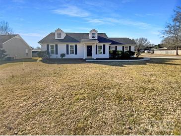 White house with black shutters, a neatly trimmed lawn, and a paved walkway at 4683 Falcon Chase Sw Dr, Concord, NC 28027