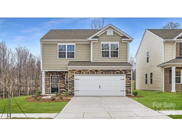 Two-story home featuring neutral siding, a two-car garage and a nicely landscaped front yard at 5725 Olive Beach Rd, Kannapolis, NC 28081