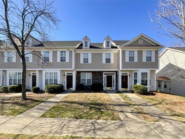 Three-story townhome with neutral siding and landscaping at 7562 Silver Arrow Dr, Charlotte, NC 28273