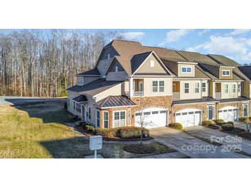 Beautiful two-story townhome with a stone facade, two-car garage, and manicured landscaping at 4194 La Crema Dr, Charlotte, NC 28214