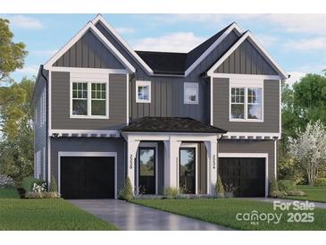 Striking two-story home with symmetrical facade, modern gray siding and black garage doors at 2238 Revolution Park Dr, Charlotte, NC 28208