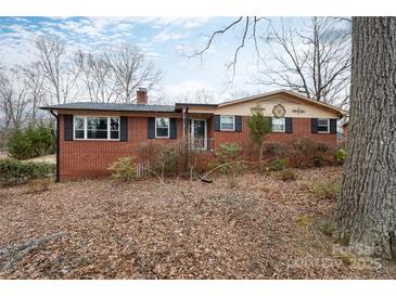 Charming brick home with black shutters, mature trees, and a well-maintained front yard at 128 Summerlea Dr, Charlotte, NC 28214